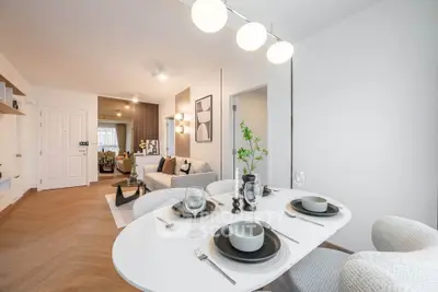 Modern open-plan living and dining area with stylish decor and elegant lighting.