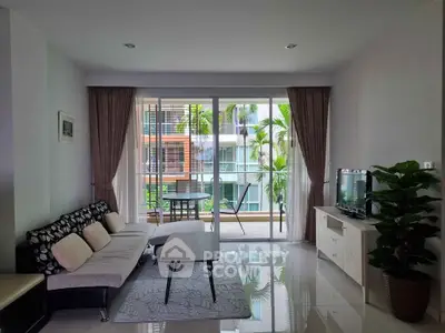 Modern living room with balcony view, stylish furniture, and natural light.