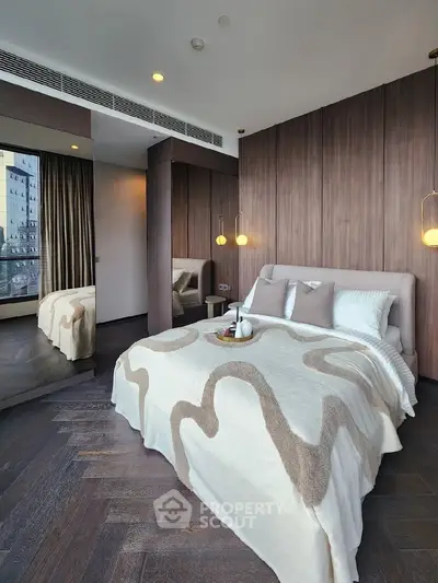 Luxurious modern bedroom with elegant decor and large mirror reflecting natural light.
