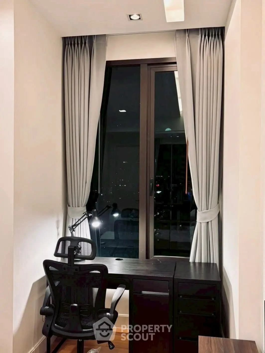 Modern study nook with sleek desk and ergonomic chair by a window with city view.