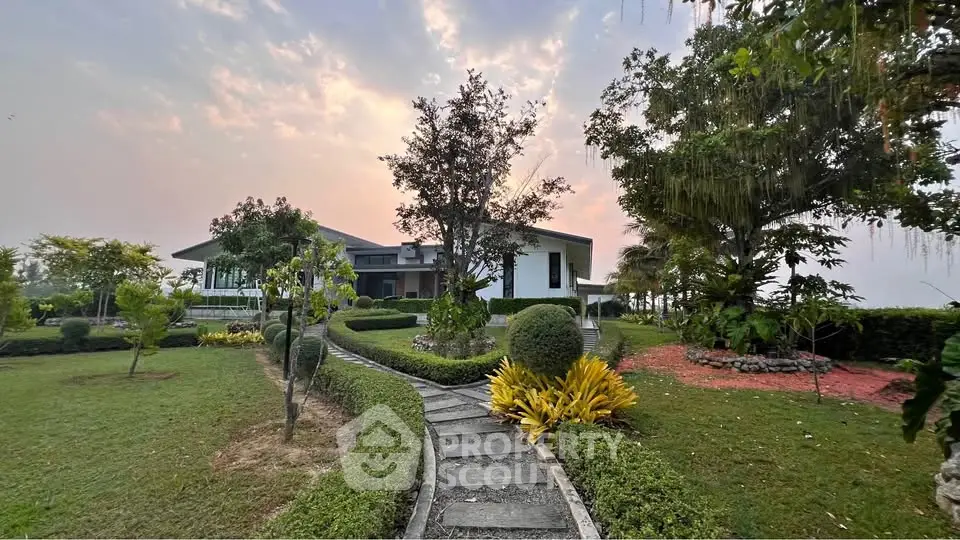 Stunning modern home with lush garden and scenic sunset view, perfect for tranquil living.
