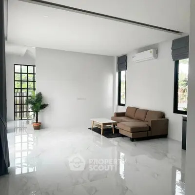 Spacious modern living room with sleek marble flooring and cozy seating area.