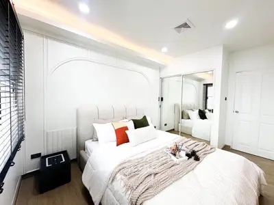 Modern bedroom with cozy decor and mirrored closet doors