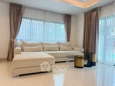 Elegant living room with modern beige sofa and stylish glass coffee tables