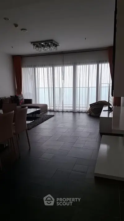 Spacious living room with large windows and modern furniture, offering a serene ambiance.