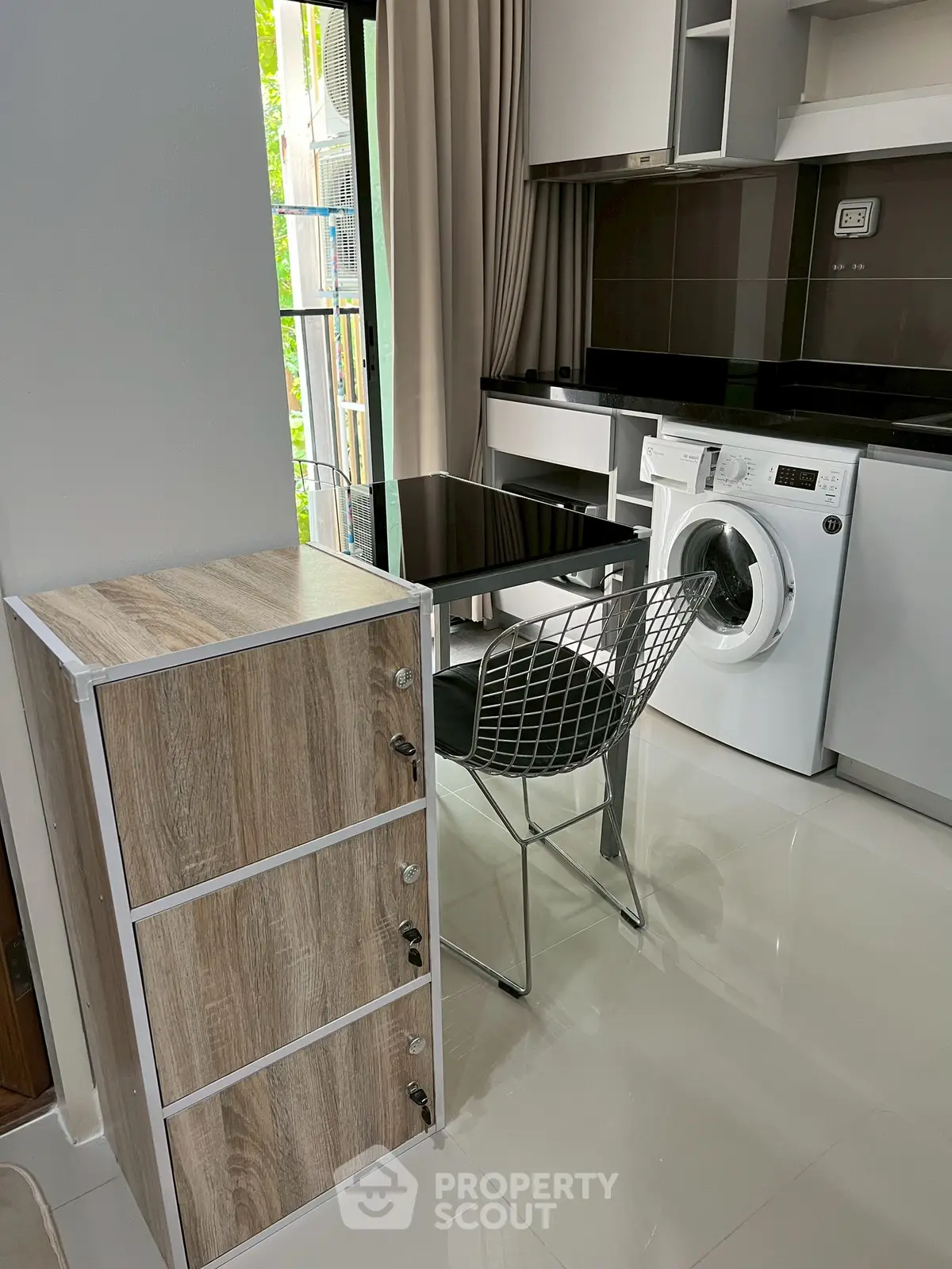 Modern kitchen with sleek appliances and stylish dining area in a compact space.