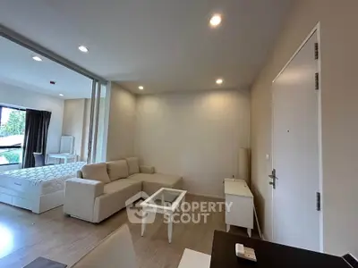 Modern open-plan living room with cozy beige sofa and natural light