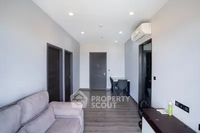 Modern living room with sleek design and air conditioning, featuring a cozy sofa and stylish flooring.