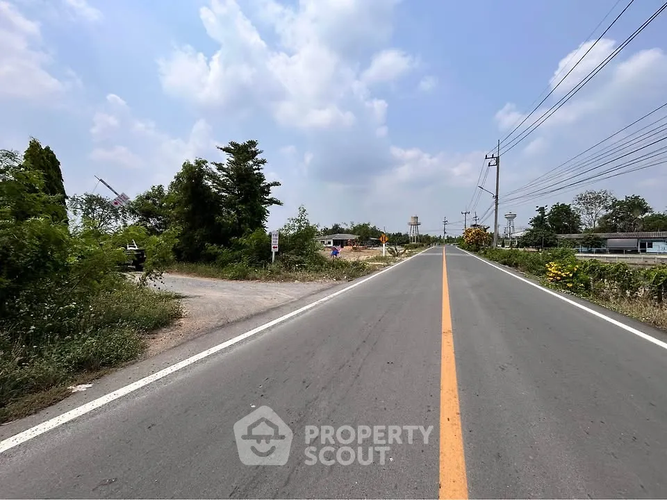 Expansive road view with lush greenery, ideal for real estate development opportunities.