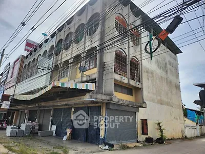 Commercial building exterior with closed shutters and street view, ideal for business opportunities.