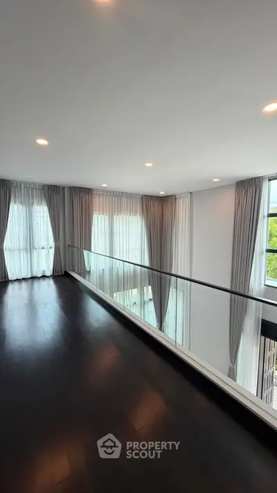 Luxurious modern living room with floor-to-ceiling windows and elegant curtains, offering abundant natural light.