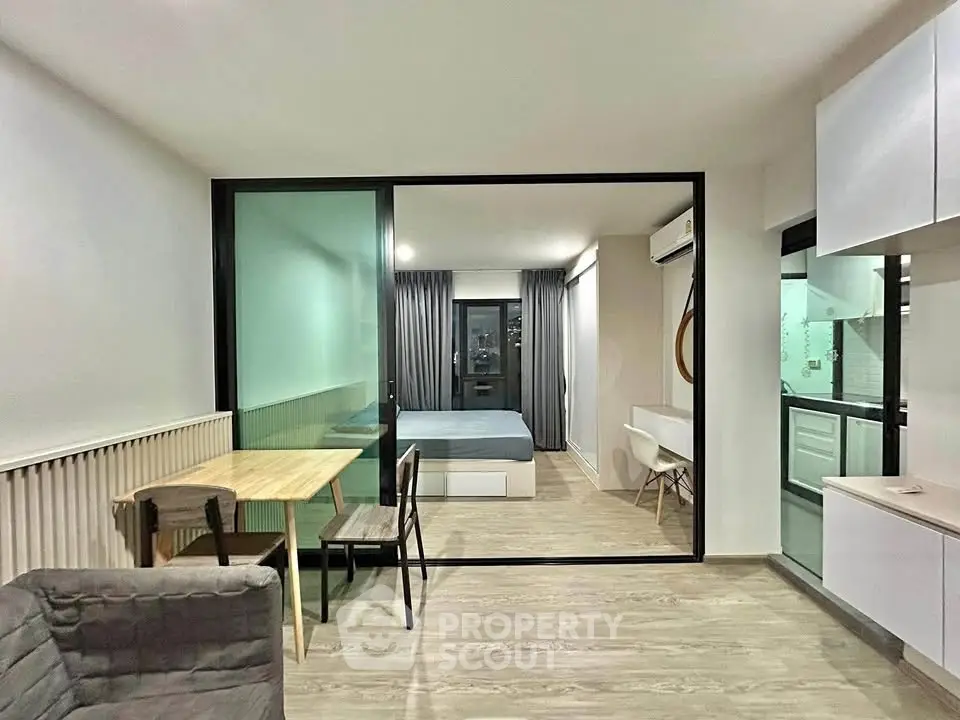 Modern studio apartment with open layout, featuring a cozy living area and sleek kitchen design.