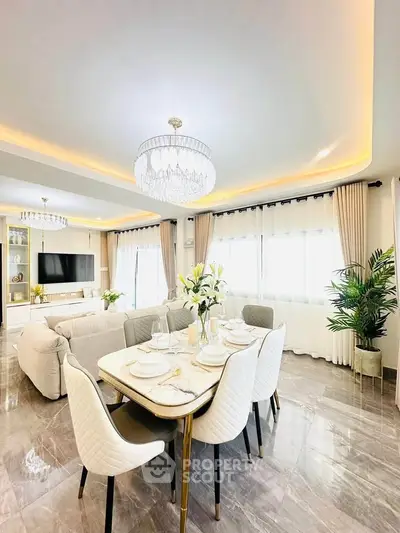 Luxurious open-plan living and dining area with elegant decor and modern lighting.