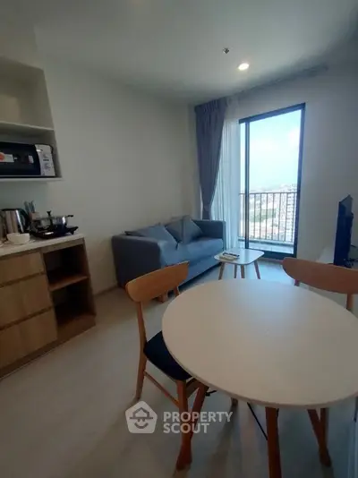 Cozy living room with modern furniture and balcony view in a stylish apartment.
