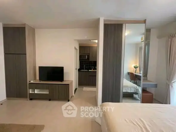 Modern studio apartment with open layout, featuring a cozy bedroom and compact kitchen area.