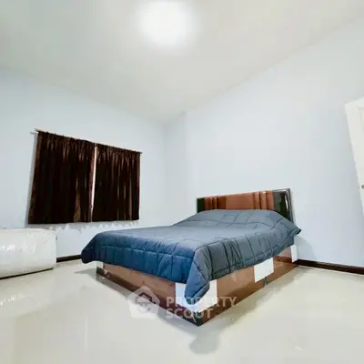 Spacious bedroom with modern bed and sleek design, perfect for relaxation.