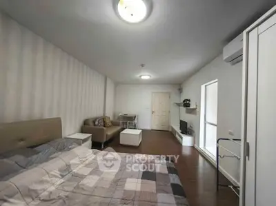 Spacious bedroom with modern decor and cozy seating area, perfect for relaxation and comfort.