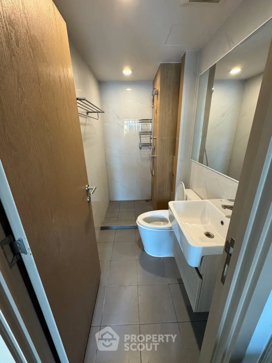 Modern bathroom with sleek fixtures and minimalist design, featuring a shower and elegant sink.