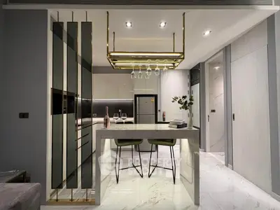 Modern kitchen with sleek design, featuring marble island and gold accents, perfect for stylish living.