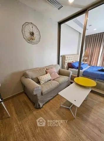 Cozy living room with modern decor and view into stylish bedroom