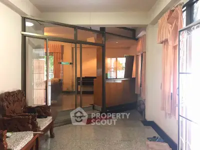 Spacious living room with elegant wooden furniture and large windows for natural light.