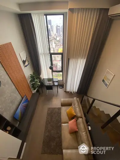 Chic high-rise living room with floor-to-ceiling windows offering a stunning cityscape view, complemented by a plush leather sofa and modern decor.