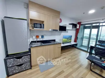 Modern studio apartment with compact kitchen and balcony view