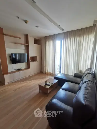 Spacious living room with modern furniture and large window for natural light.