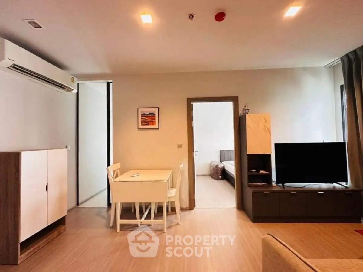 Modern living room with dining area and bedroom view in a stylish apartment.