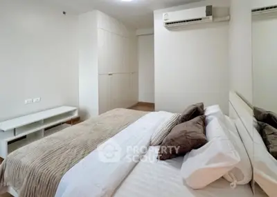 Spacious bedroom with modern decor and built-in wardrobe, perfect for comfortable living.
