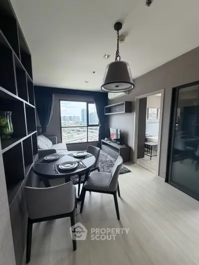 Modern living room with dining area and city view, featuring sleek furniture and stylish decor.