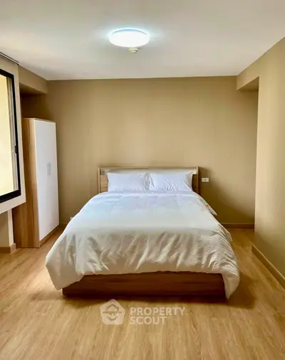 Spacious bedroom with modern design and natural light in a stylish apartment.