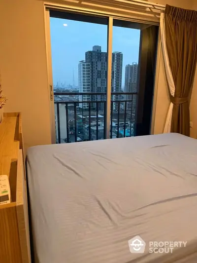 Modern bedroom with city view from balcony in high-rise apartment