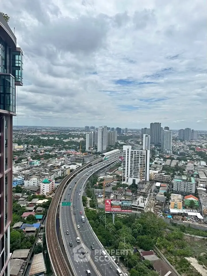 Stunning cityscape view from high-rise building showcasing urban skyline and highway.