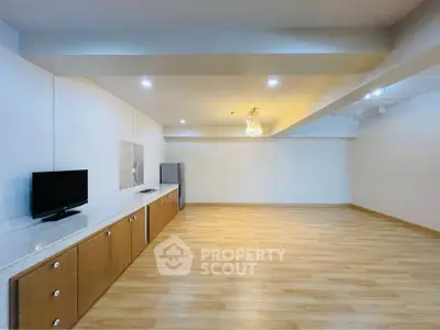 Spacious modern living room with wooden flooring and sleek cabinetry