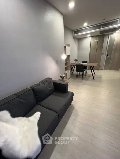 Modern living room with sleek furniture and open dining area, perfect for contemporary living.