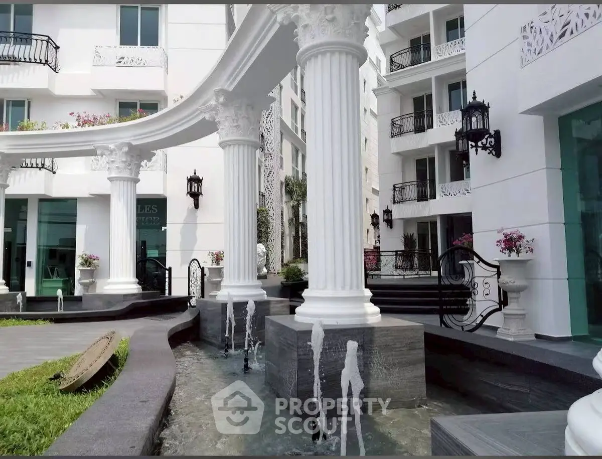 Luxurious apartment building entrance with elegant columns and water features