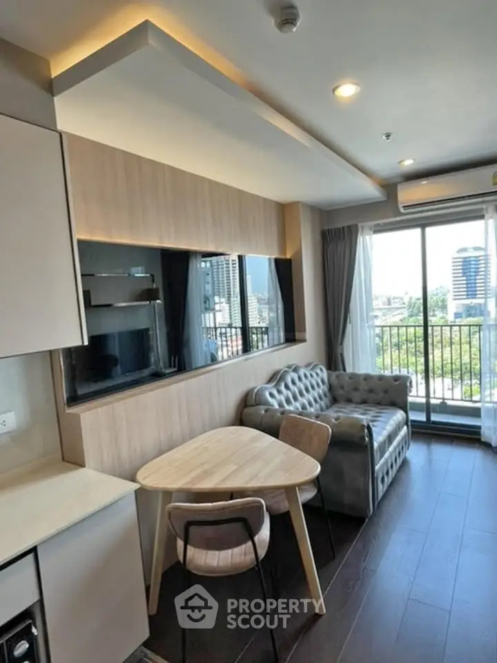 Modern living room with chic sofa, dining table, and balcony view in urban apartment.