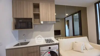 Modern compact kitchen with integrated washing machine and cozy living area