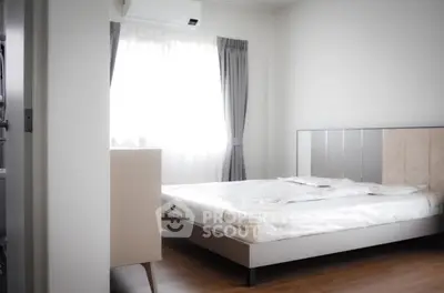 Modern bedroom with natural light, featuring a sleek bed and minimalist decor, perfect for a cozy retreat.