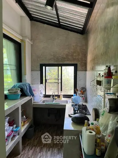 Cozy kitchen with open layout and gas stove, featuring natural light and modern design.