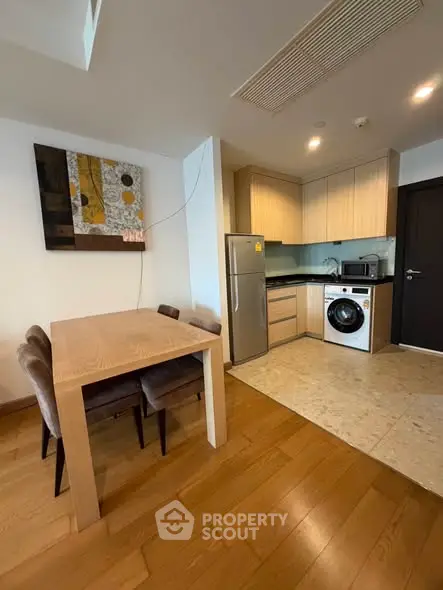Modern kitchen with dining area, featuring sleek appliances and stylish decor.