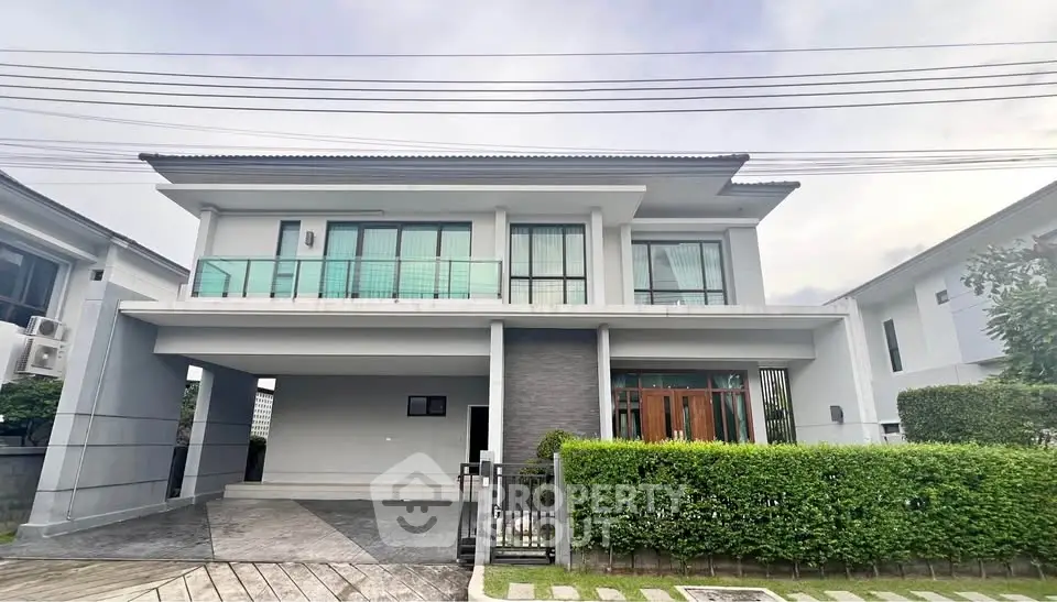 Modern two-story house with large windows and a spacious driveway in a suburban neighborhood.