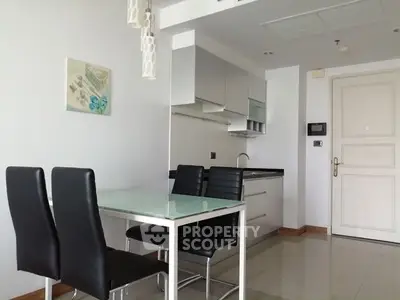 Modern kitchen with sleek design and dining area in contemporary apartment.