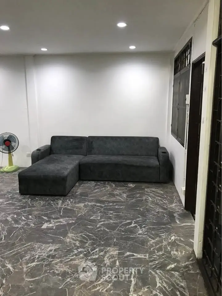 Spacious living room with modern gray sofa and marble flooring