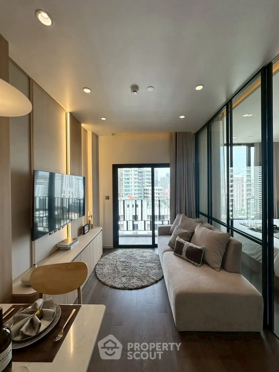 Modern living room with city view, sleek furniture, and elegant decor in a high-rise apartment.