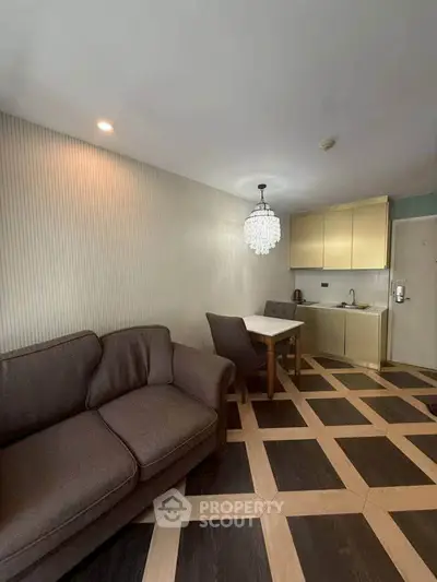 Modern living room with elegant chandelier and stylish kitchen in open layout apartment.