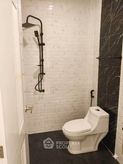 Modern bathroom with sleek black and white tiles and contemporary fixtures.
