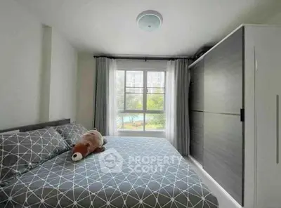 Cozy bedroom with large window and modern wardrobe, perfect for relaxation.