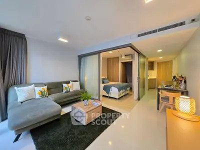 Modern living room with cozy seating and stylish decor in open-plan apartment.